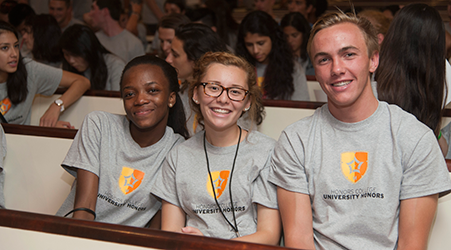 three fresham in matching UH shirts sit on bench and smile